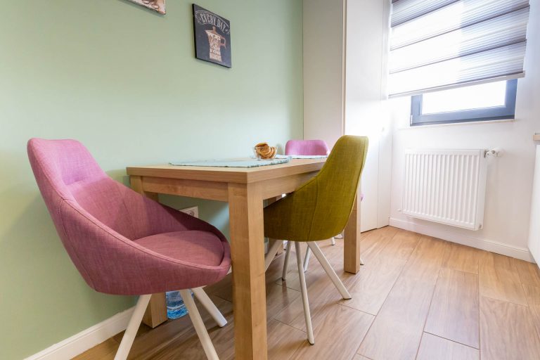 design-interior-apartament-bucatarie-masa-pal-scaune-colorate-perete-verde